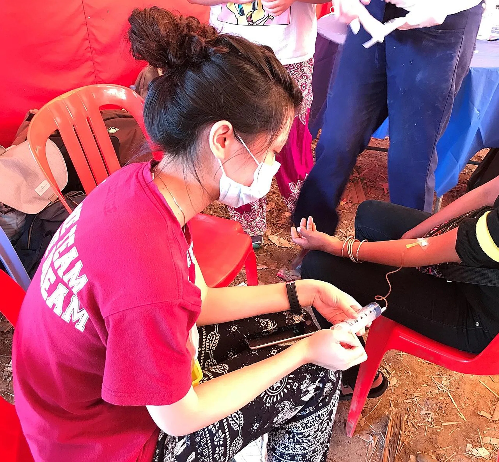 Ms Celine Lee helping sick villagers on a medical mission to Cambodia. 