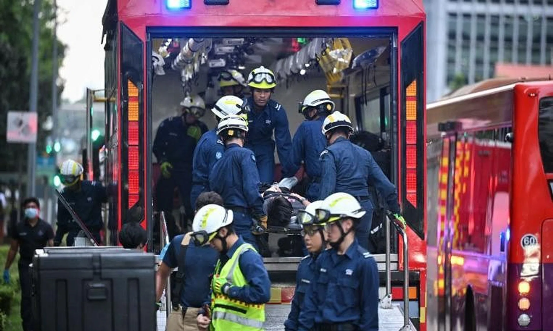 Casualties being transferred to a mass decontamination vehicle outside One Raffles Quay.