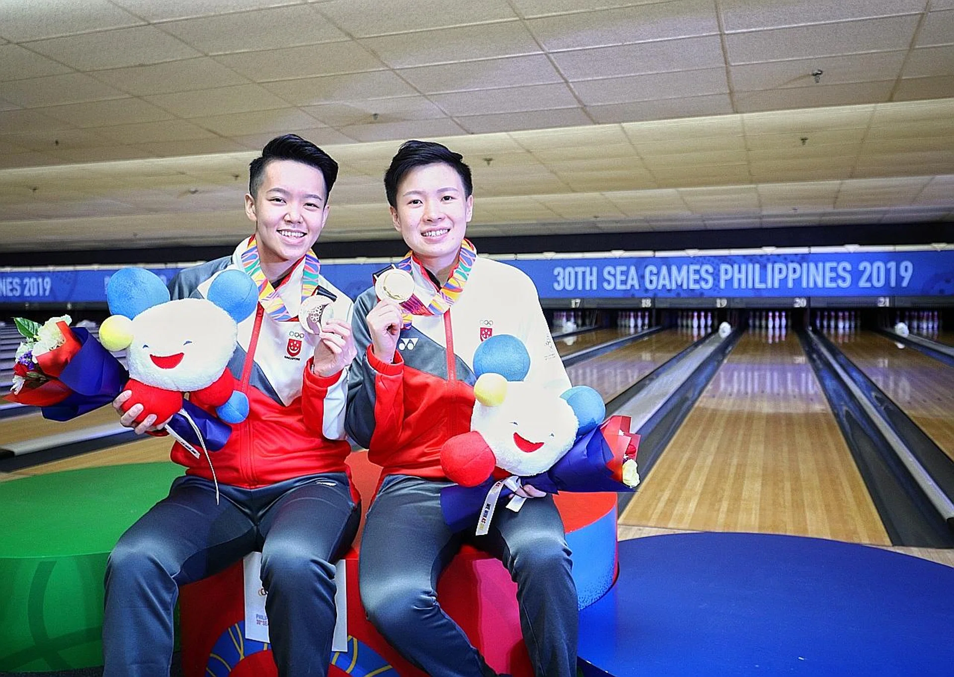 Gold medallist New Hui Fen (right) and bronze medallist Shayna Ng celebrating their podium finishes in yesterday's women's singles. 