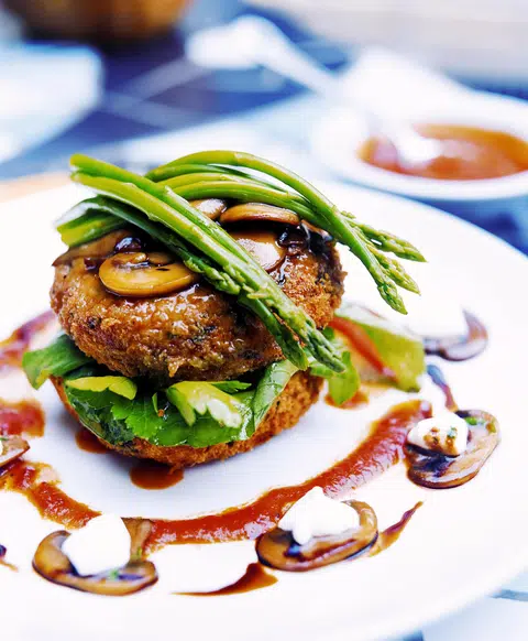 Bosco Misto, a popular menu item at Original Sin, features spinach, feta and tofu patties coated in almonds and sesame, served with asparagus and a mushroom plum sauce.