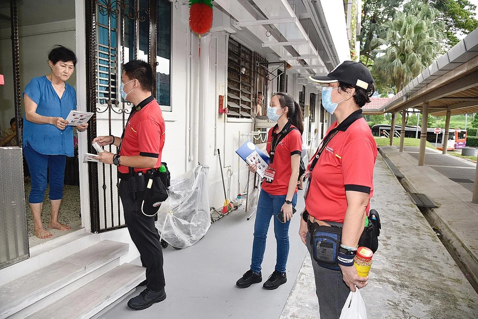 Volunteers from Queenstown HeartSavers distributing pamphlets on dengue prevention to residents. 