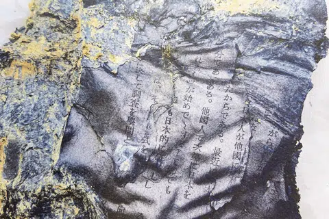 A close-up of a printout picture of the carbonized Japanese literature found during a 2021 excavation.