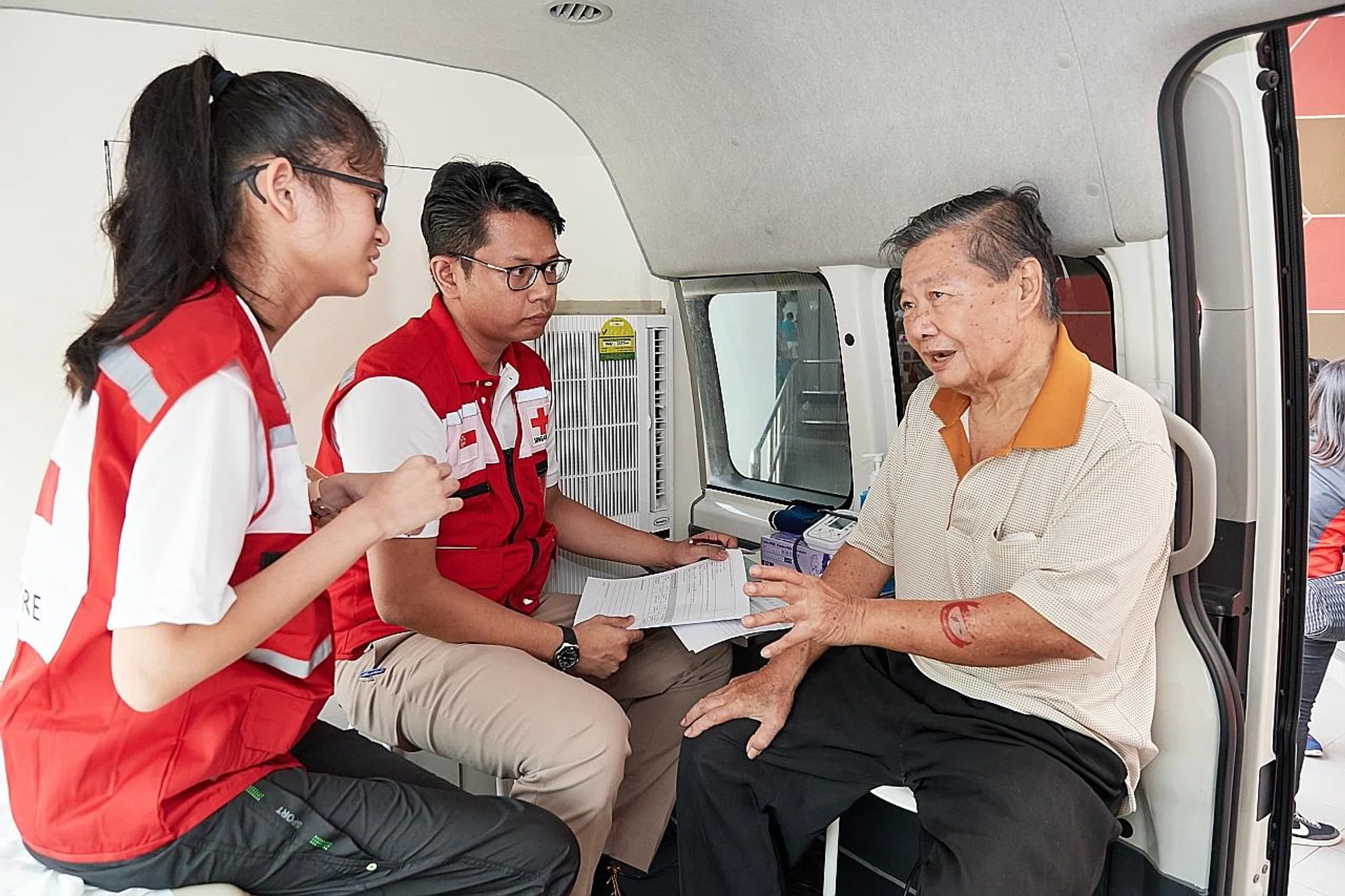 Tampines resident Tan Joon Chye, 74, who had a heart bypass in January, speaking to volunteers in the Community Health on Wheels van.