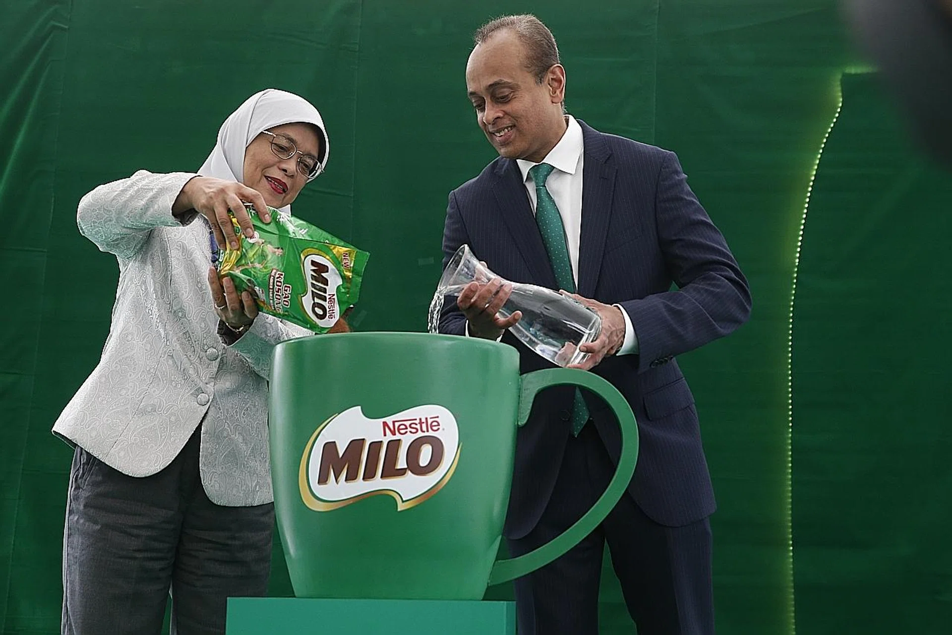 President Halimah Yacob helping to make the first cup of Milo Gao Kosong with Nestle Singapore's managing director Rajiv Deraniyagala. 