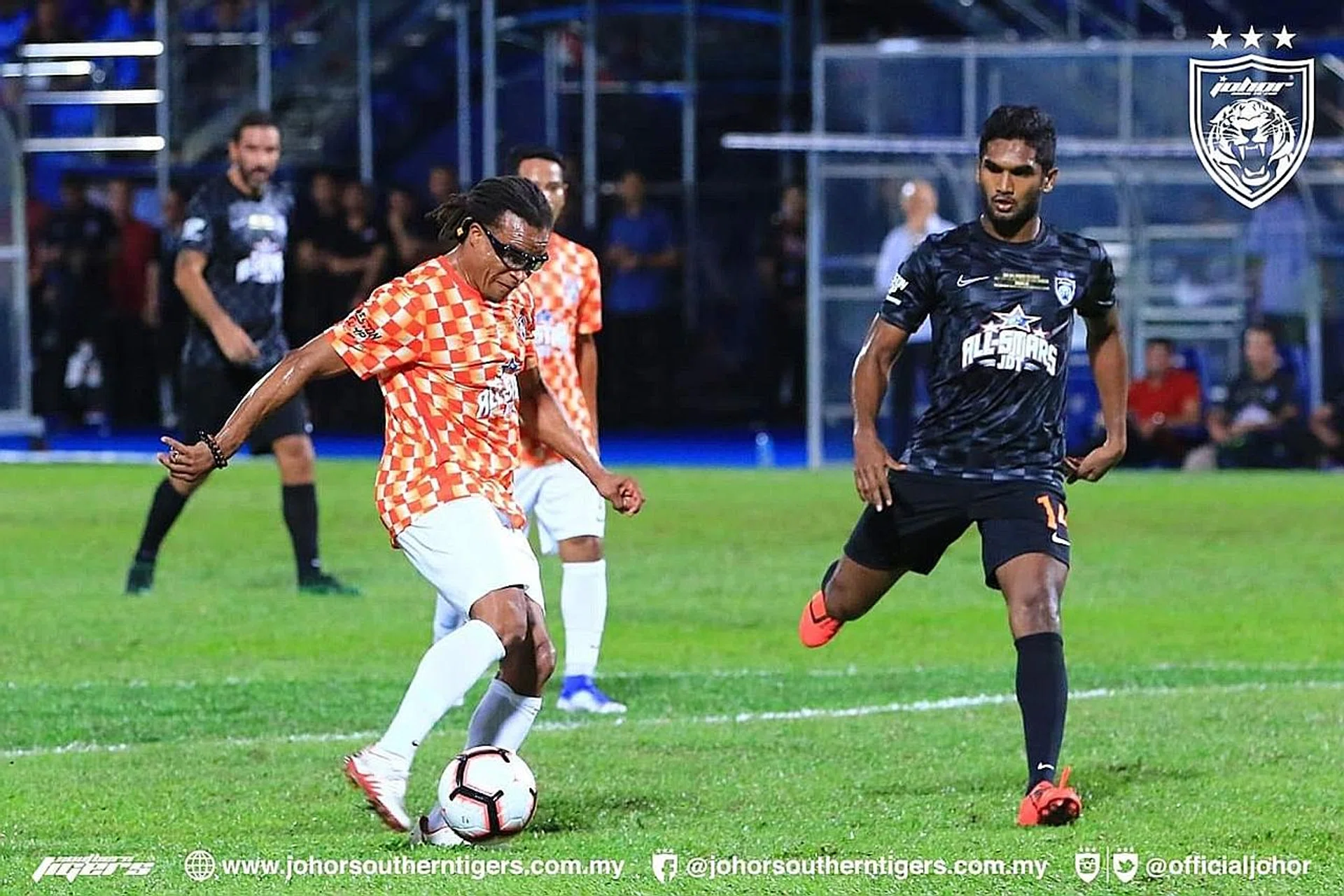Lions midfielder Hariss Harun (right) closing down Dutch legend Edgar Davids in a charity match at Johor's Larkin Stadium on Sunday.