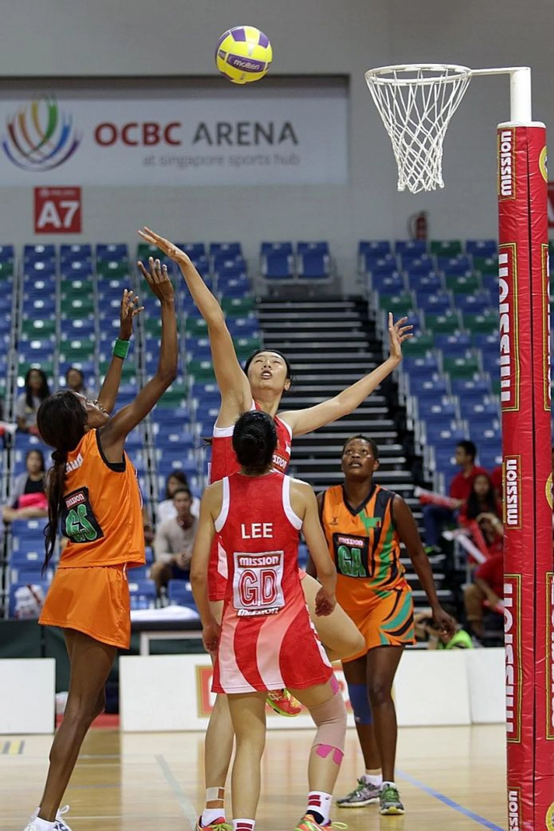 DEFENCE: Singapore's Chen Lili (below) attempts to block a shot from a Zambia player in their match in the Mission Foods Nations Cup.