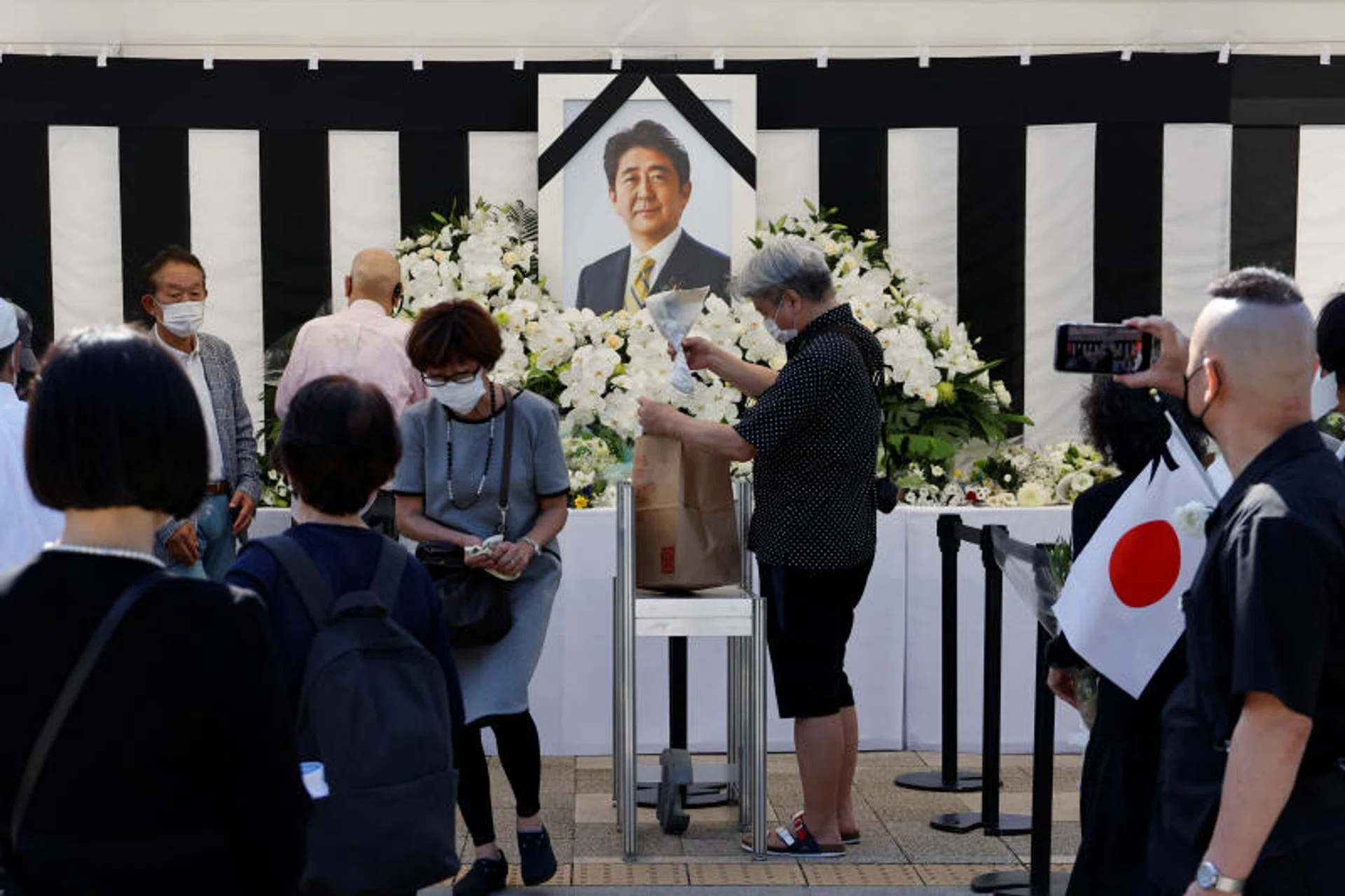 Mourners offer flowers at the altar outside Nippon Budokan Hall which will host a state funeral for former Prime Minister Shinzo Abe in Tokyo, Japan, Sept 27, 2022.
