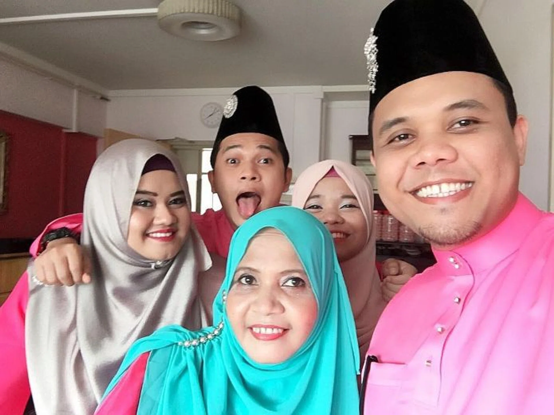 UPBEAT: Mr Mohammad Ridzwan Abdol Latiff (forefront) with his mother Juraida. At the back are (from far left) his sister Nur Ain, brother Mohammad Radzaly and sister Nur Ashaqira.