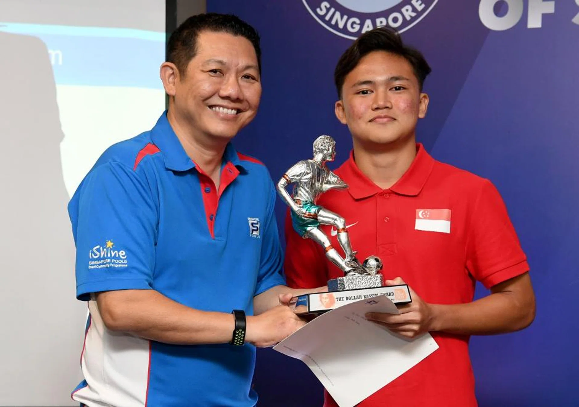Iman Hakim Ibrahim (right) receiving the TNP Dollah Kassim Award from Chin Sau Ho, Singapore Pools' director of community partnerships and communications.