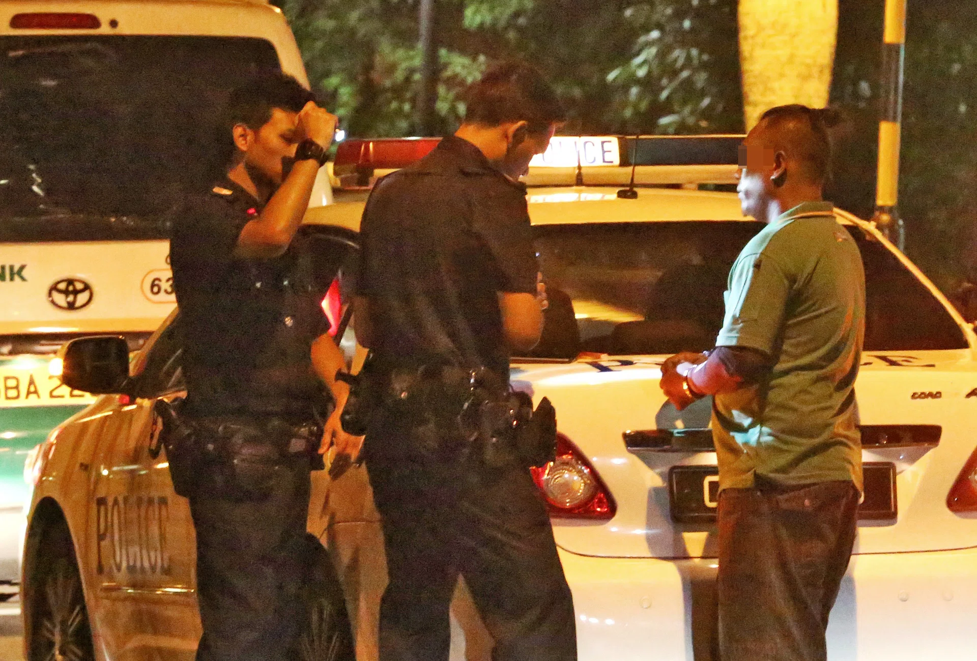 FIGHT: (Above) The man being questioned by the police is believed to be the boyfriend of the woman found lying on the road.