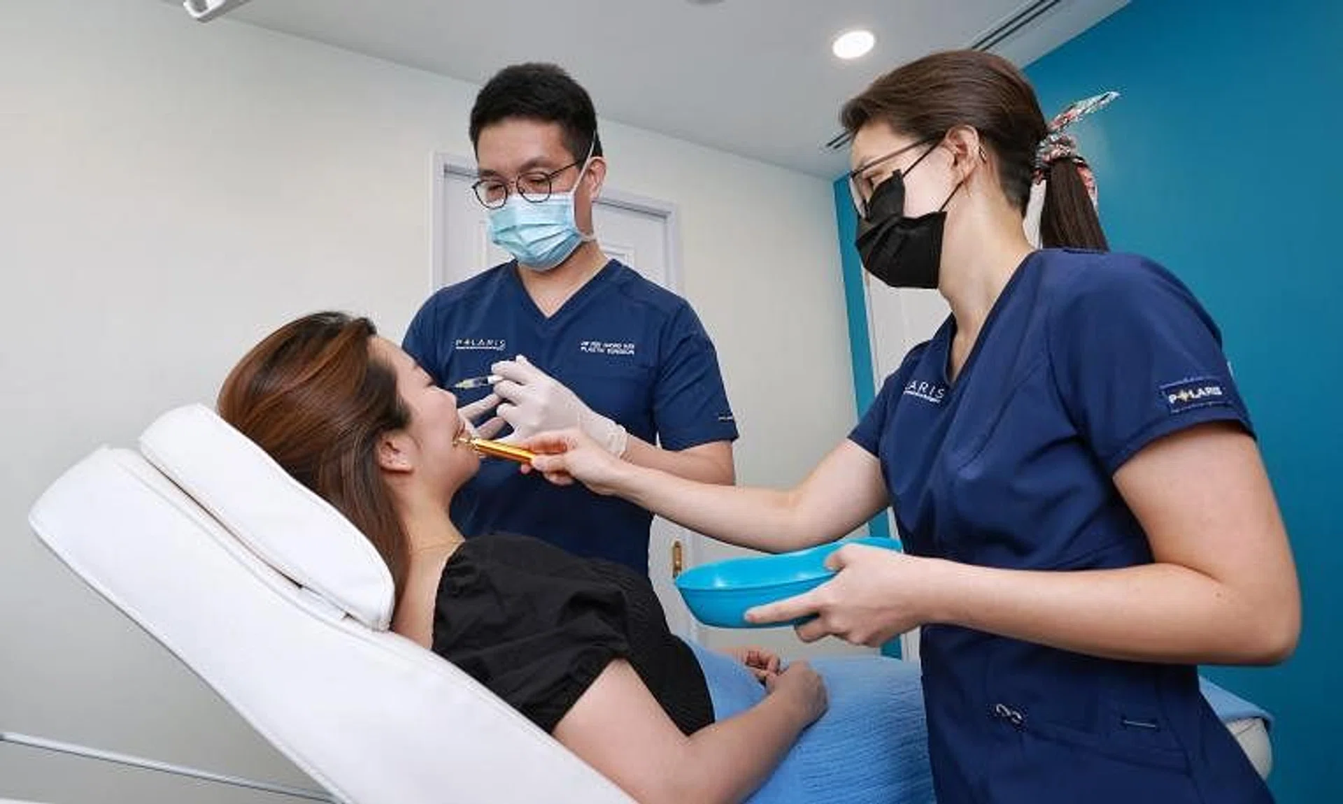 Dr Pek Chong Han (centre) conducting a demonstration of a procedure on a patient at Polaris Plastic and Reconstructive Surgery.