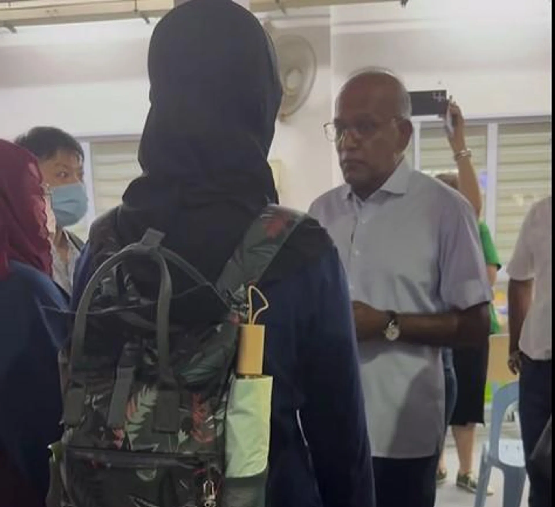 Mr Shanmugam speaking to the two women after the pair shouted "coward" at him.