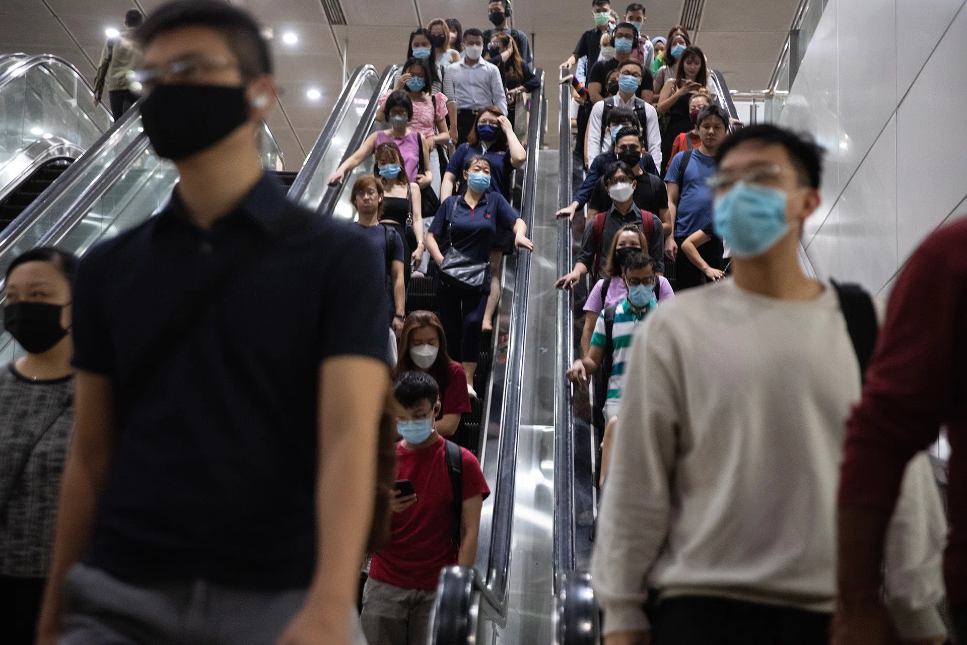 People take the escalator in an underground MRT train station on Feb 13, 2023.