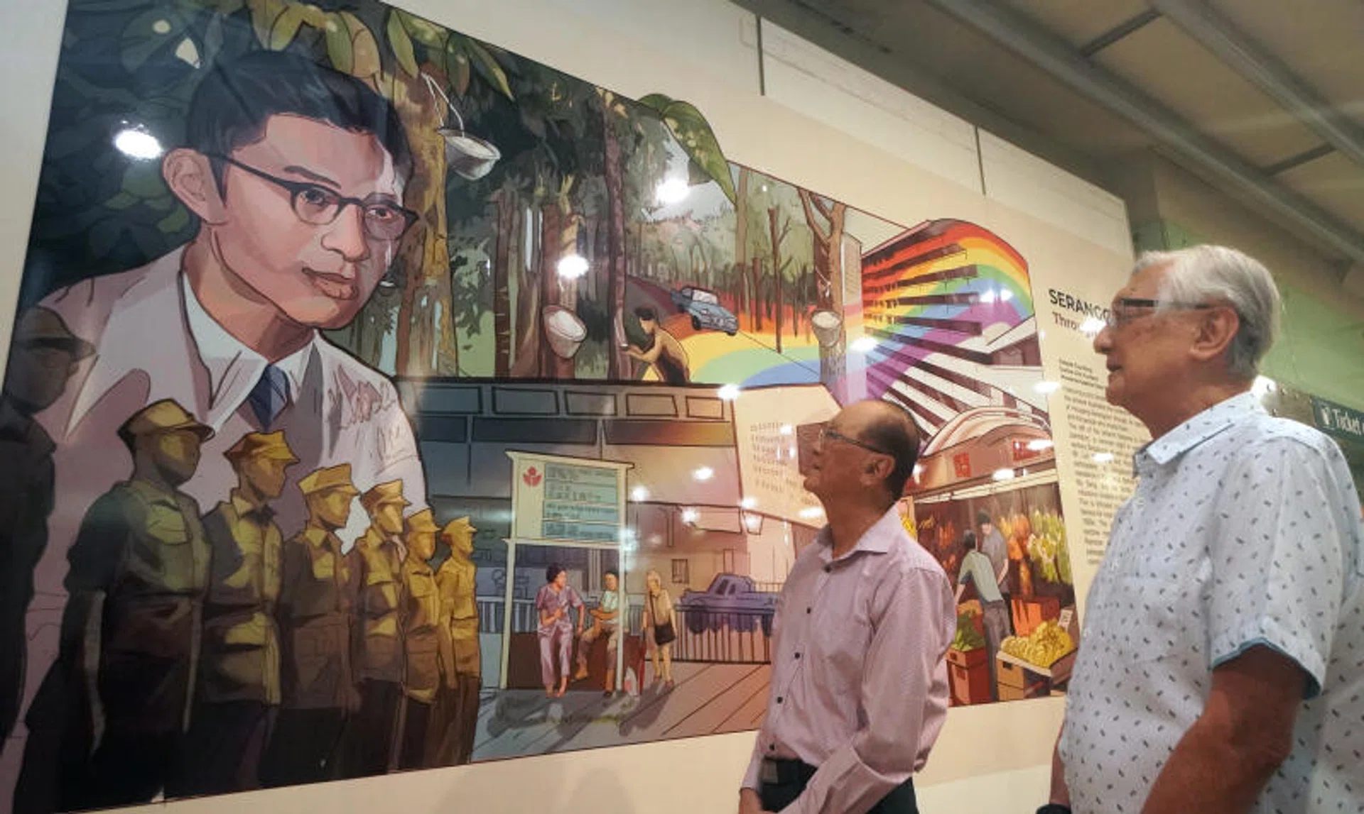 Dr Lim Whye Geok (pink top) and Mr Lim Lam Geok, the children of WWII hero Lim Bo Seng, with the mural featuring their late father at Serangoon MRT station.