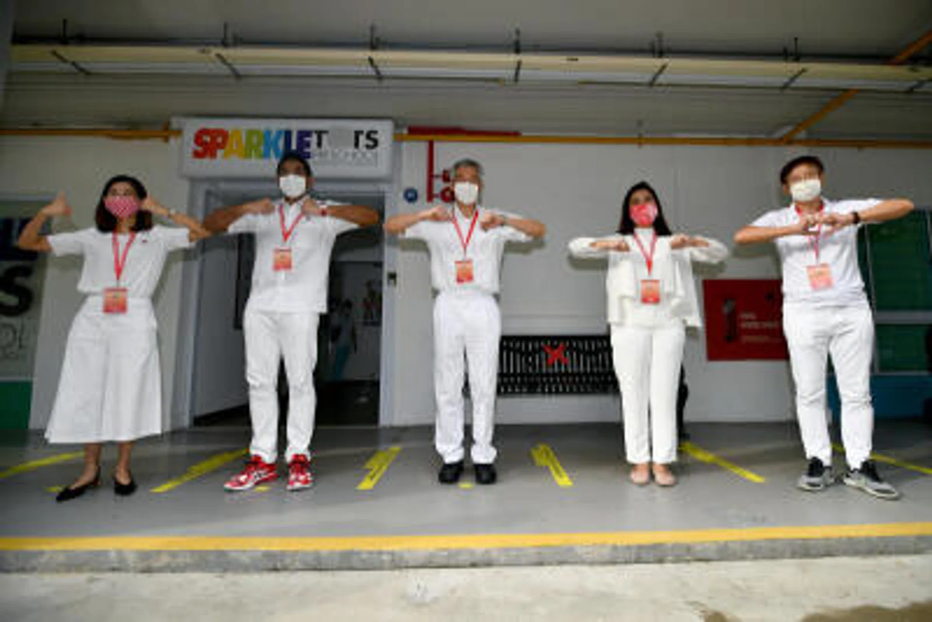 PM Lee Hsien Loong (centre), with (from left to right) Ms Ng Ling Ling, Mr Darryl David, Ms Nadia Ahmad Samdin and Mr Gan Thiam Poh taking a group photograph outside the PAP Teck Ghee branch at Ang Mo Kio Ave 3 on July 10, 2020.