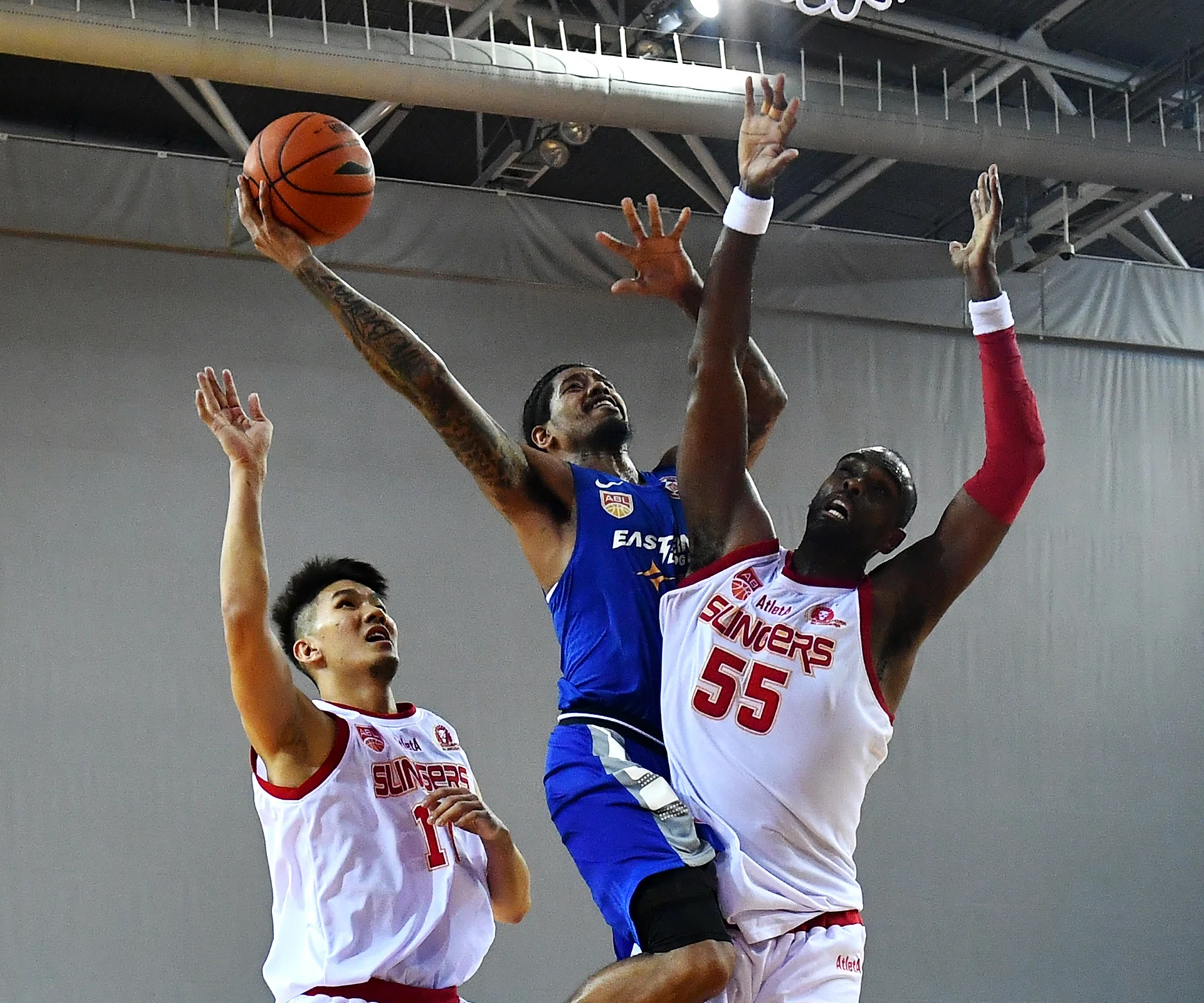 Singapore Slingers' Justin Howard (No. 55) and Ng Han Bin trying to stop Hong Kong Eastern Long Lions' Tyler Lamb. 