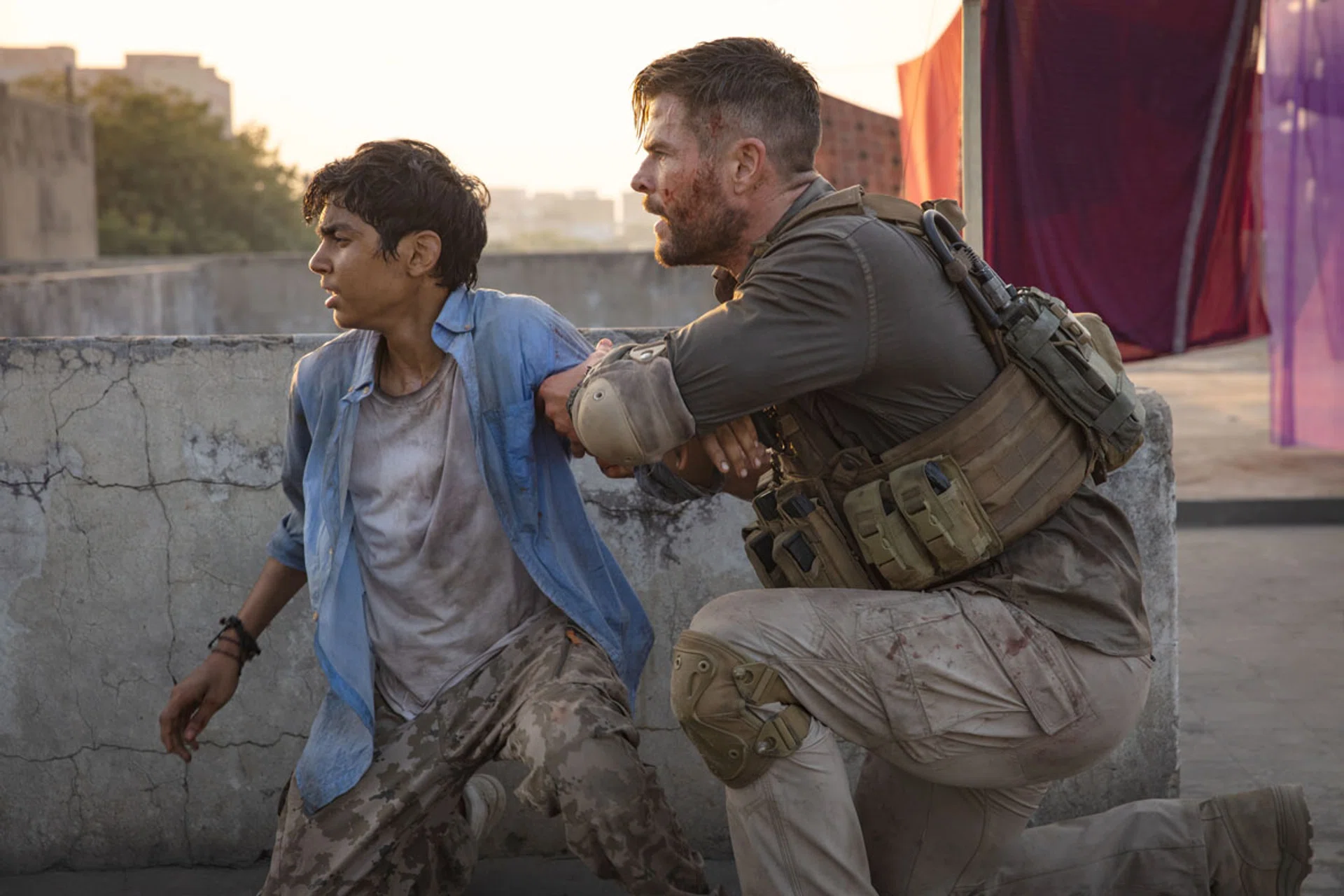 (Above) Chris Hemsworth plays a mercenary rescuing a crime lord's son, played by Rudhraksh Jaiswal.