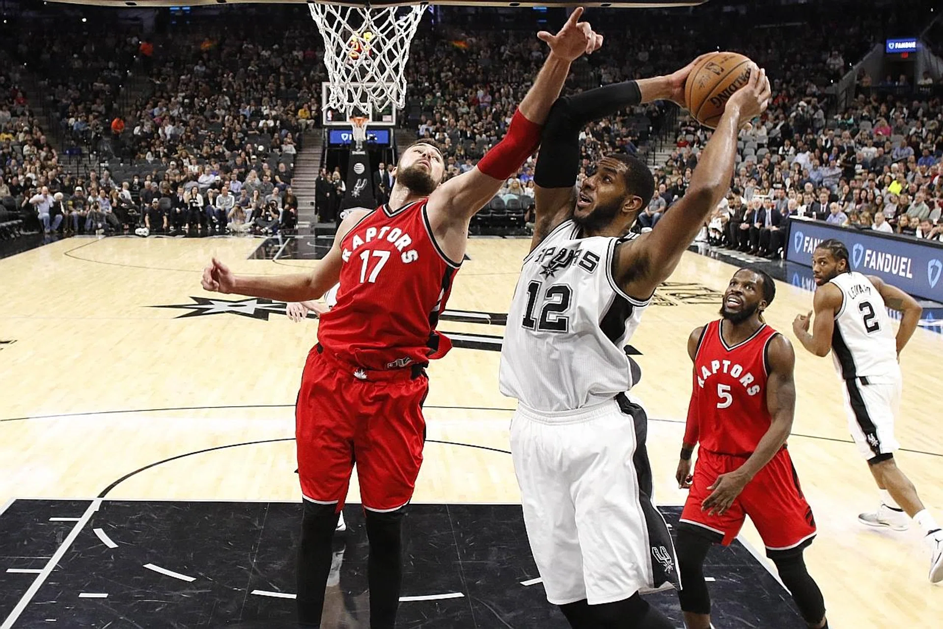 San Antonio Spurs forward LaMarcus Aldridge (second from left) beats Toronto Raptors centre Jonas Valanciunas (far left) to a rebound. 
