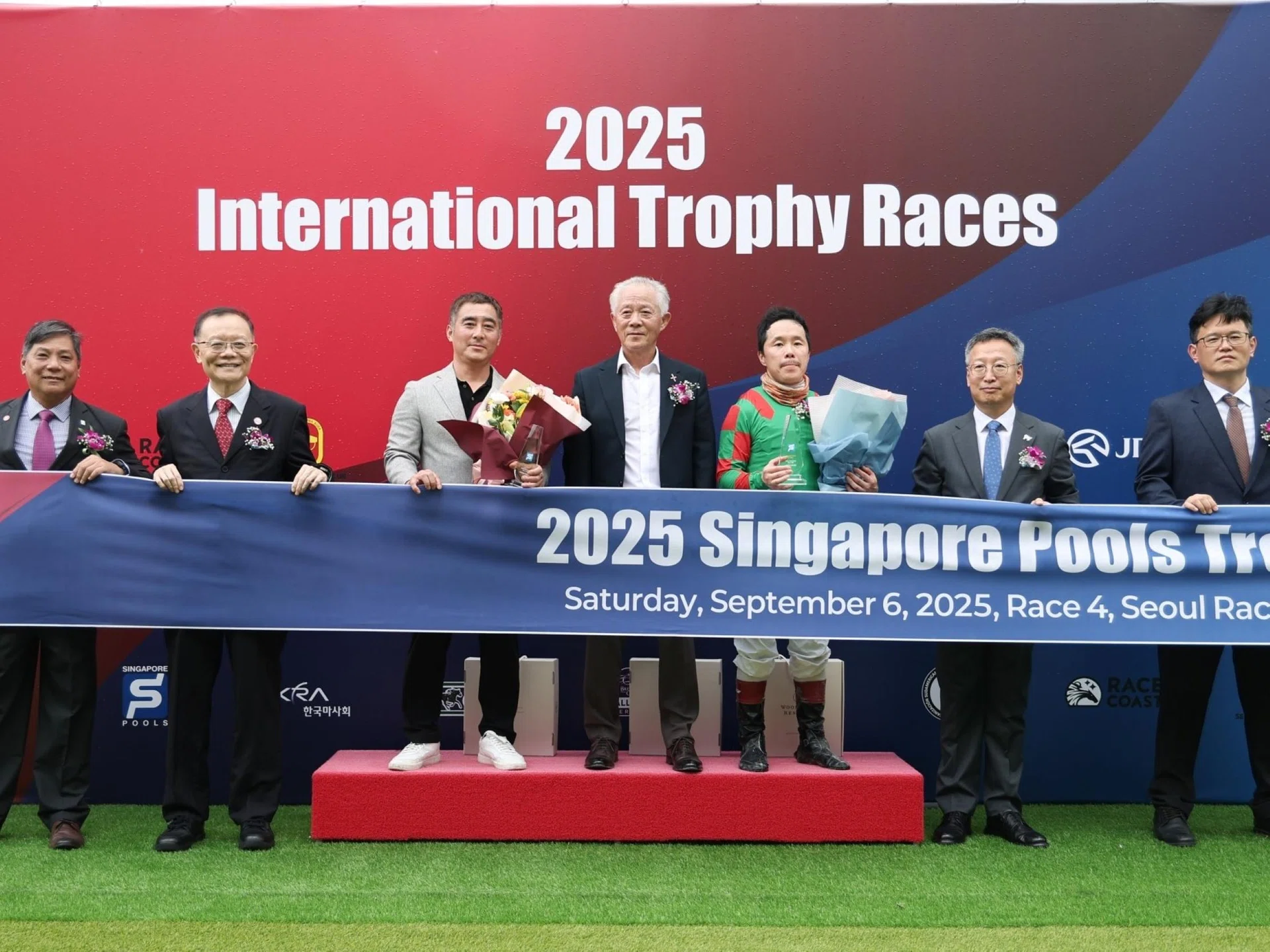 Singapore Pools chief product officer Simon Leong (left), board member and Tote Board chief executive Tan Choon Shian (second from left), Korea Racing Authority executive director Song Dae-young (second from right) and racing operations general manager Yeo Hak-soo (right) celebrating with trainer Park Jee-heon (third from left), owner-representative Park Dae-heung (middle) and jockey Choi Bum-hyun after Best Race landed the Singapore Pools Trophy (1,200m). 
