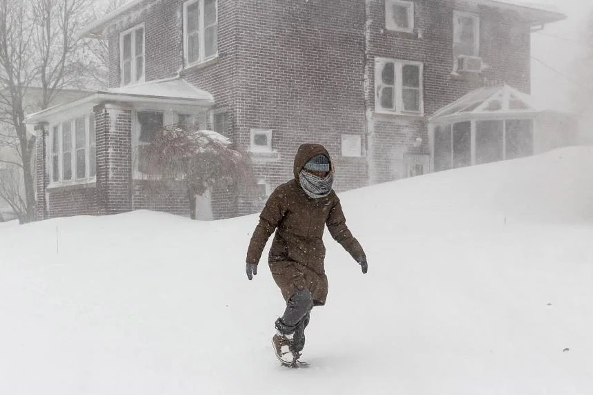 A woman attempts to walk through deep snow during a winter storm in Buffalo, New York, on Dec 24, 2022. 
