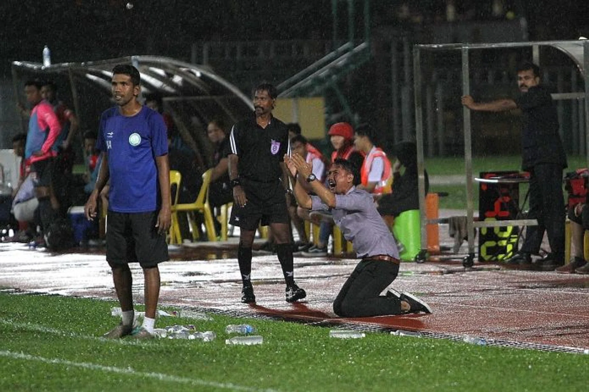 PLEA: Geylang coach Hasrin Jailani (above) on his knees after a foul against his team is not given.