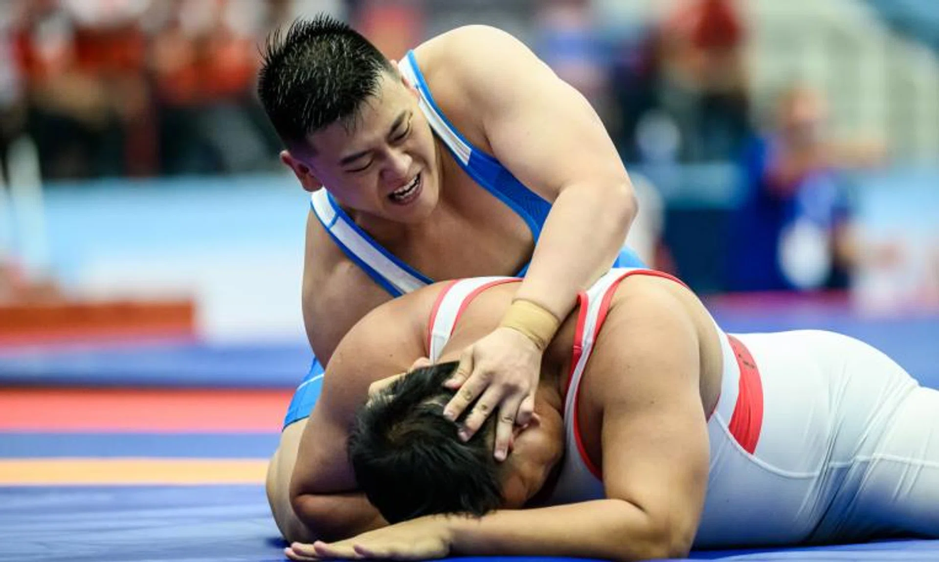 Timothy Loh in control against Laos' Xaisomboun Phetsouphane in their Greco-Roman wrestling 130kg bout on May 17.
