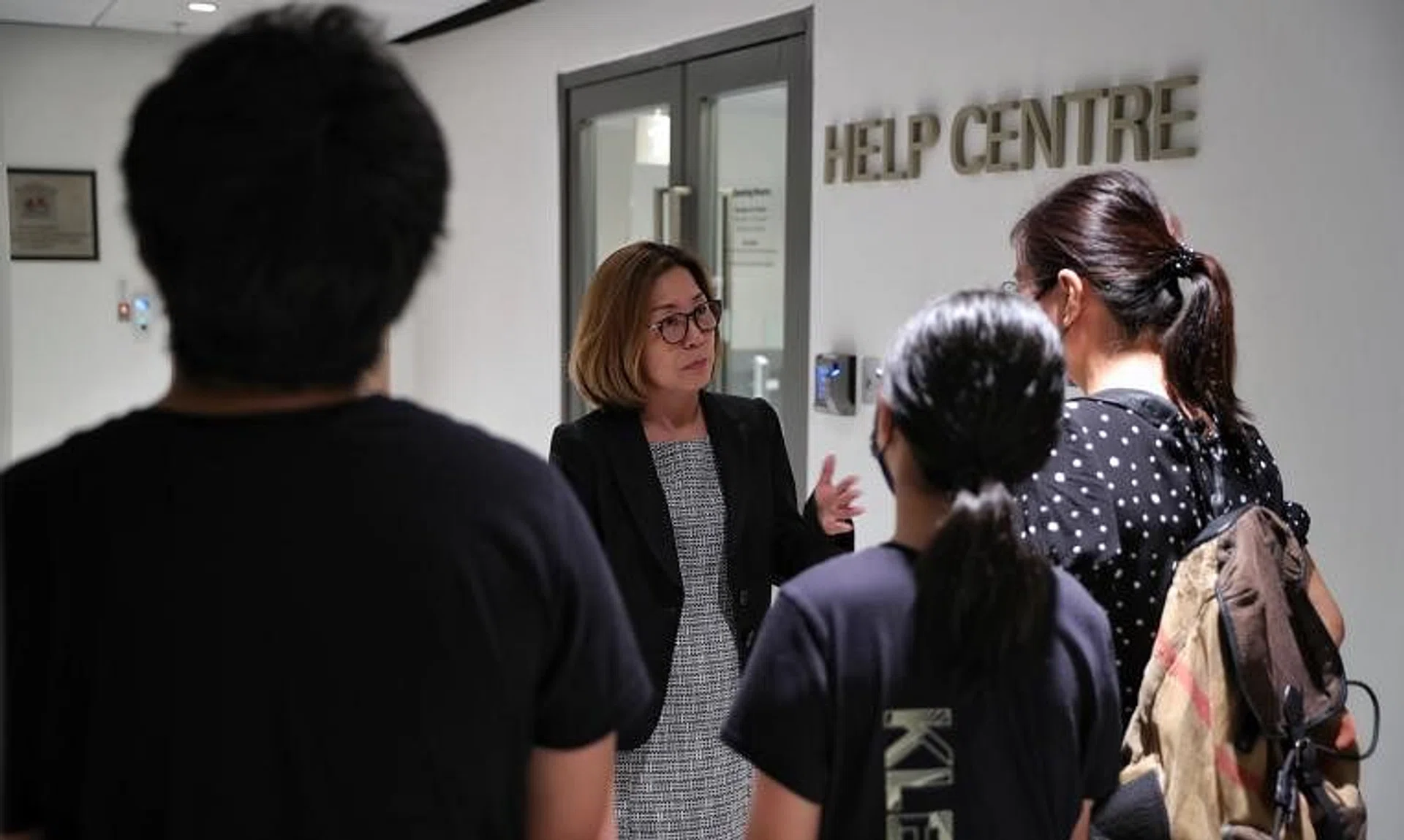 Volunteer lawyer Wong Soo Chih speaks to a Malaysian mother and her two Singaporean children at the State Courts on Oct 19, 2022.