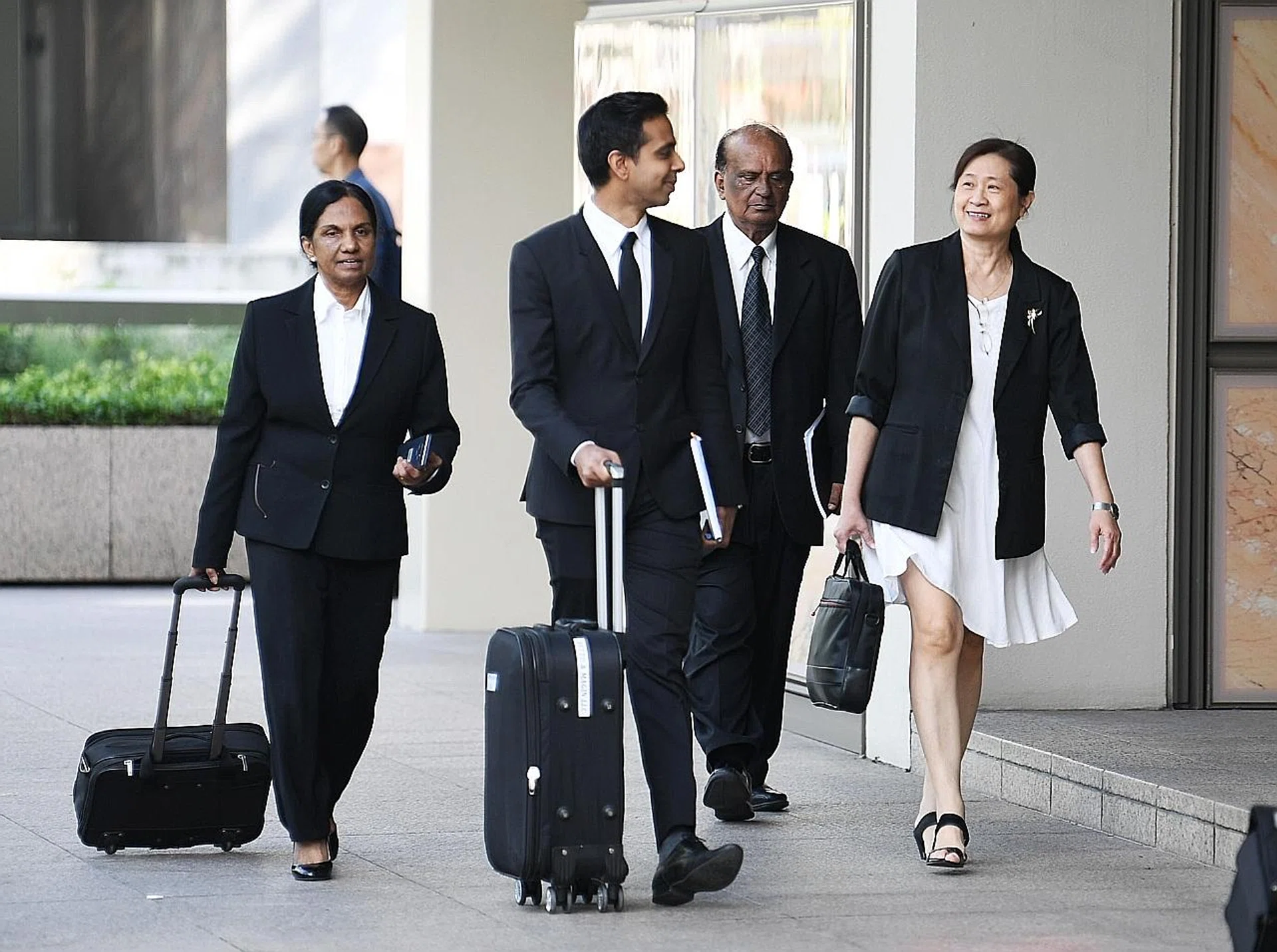FMSS majority owner How Weng Fan (right) with the lawyers, including Mr Leslie Netto (centre). The defence continued its cross-examination of KPMG executive director Owen Hawkes yesterday. 