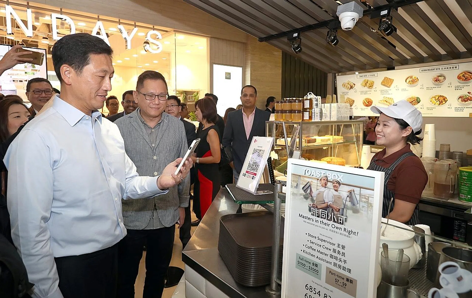 Mr Ong Ye Kung (left), accompanied by Mr Vincent Lim, regional general manager ,Toast Box, making his purchase using QR code with his handphone. 