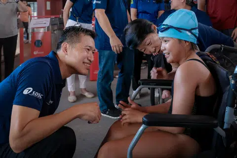 Acting Minister for Culture, Community and Youth David Neo (left) greeting para-swimmer Raelynn Foo, 10, at the 100-day countdown celebration to the World Para Swimming Championships.