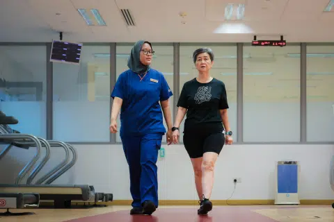 Senior physiotherapist Nadiah Mohamed Rahim gets Madam Teo to warm up with a walk before exercise.