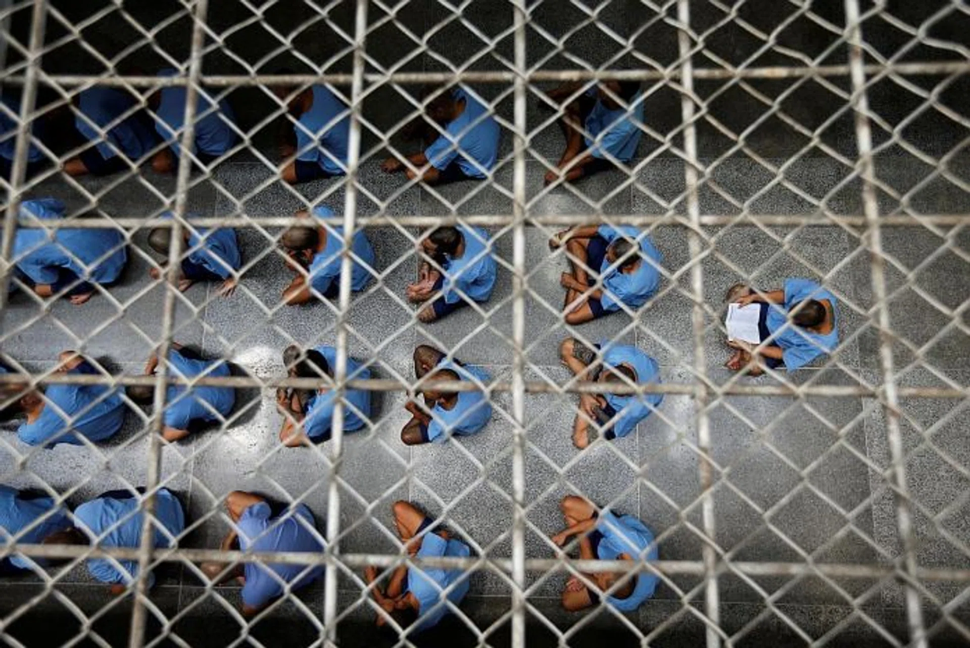 LIFE IN KLONG PREM: (Above) Inmates sitting in rows during an inspection visit; a cell with a toilet where five inmates sleep; visitors speaking by phone to inmates.