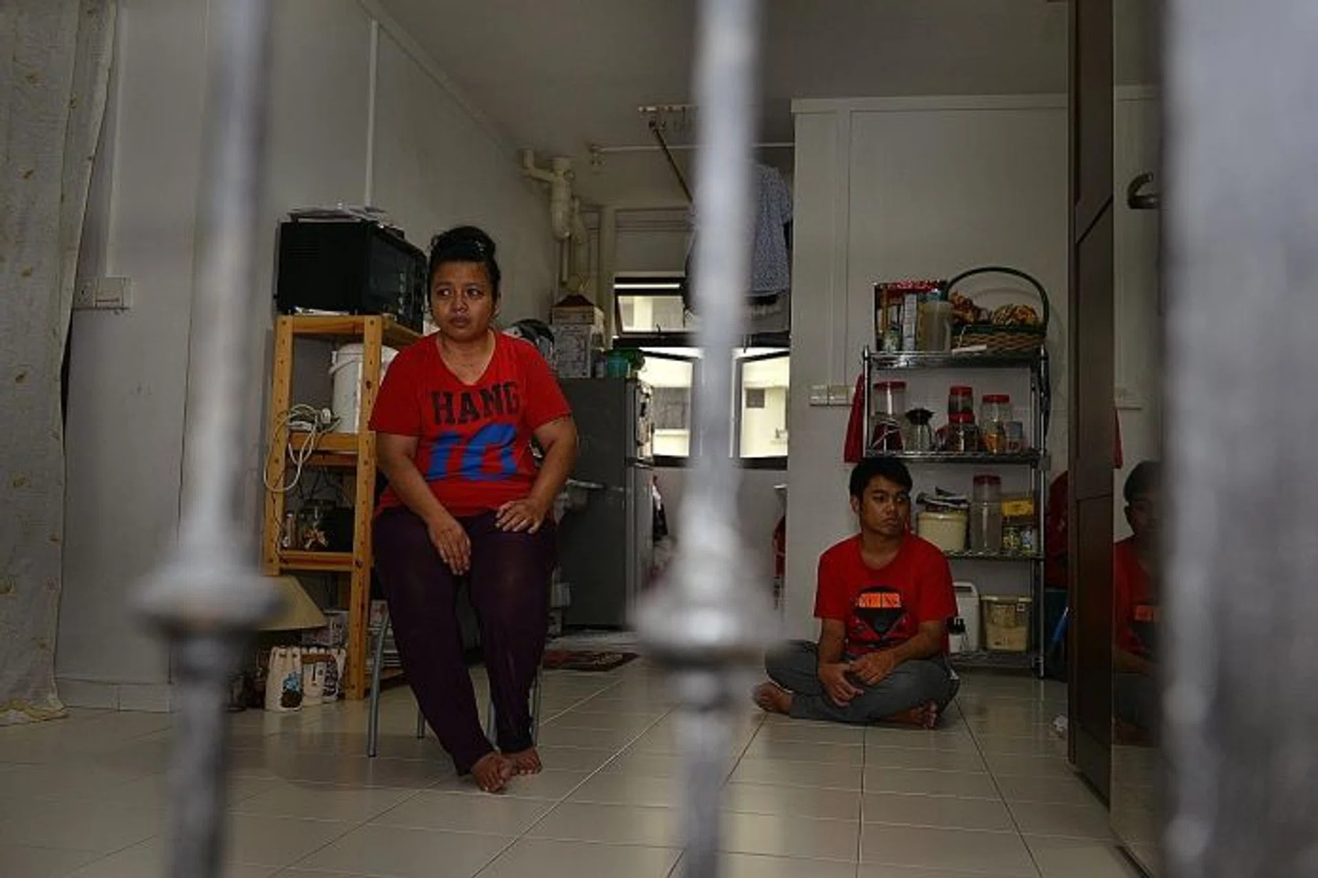 VICTIM: Madam Jurina with one of her two sons, Mr Muhammad Shahirul Junadi, who is autistic, in their one-room rental flat.