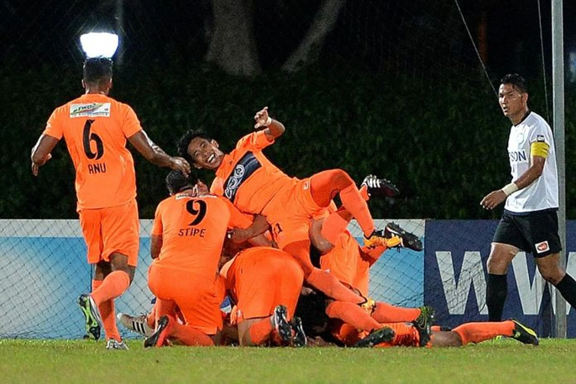 SLIPPING DOWN: Geylang skipper Isa Halim (right) can't prevent his team from falling to seventh in the table after being defeated by Hougang (left).