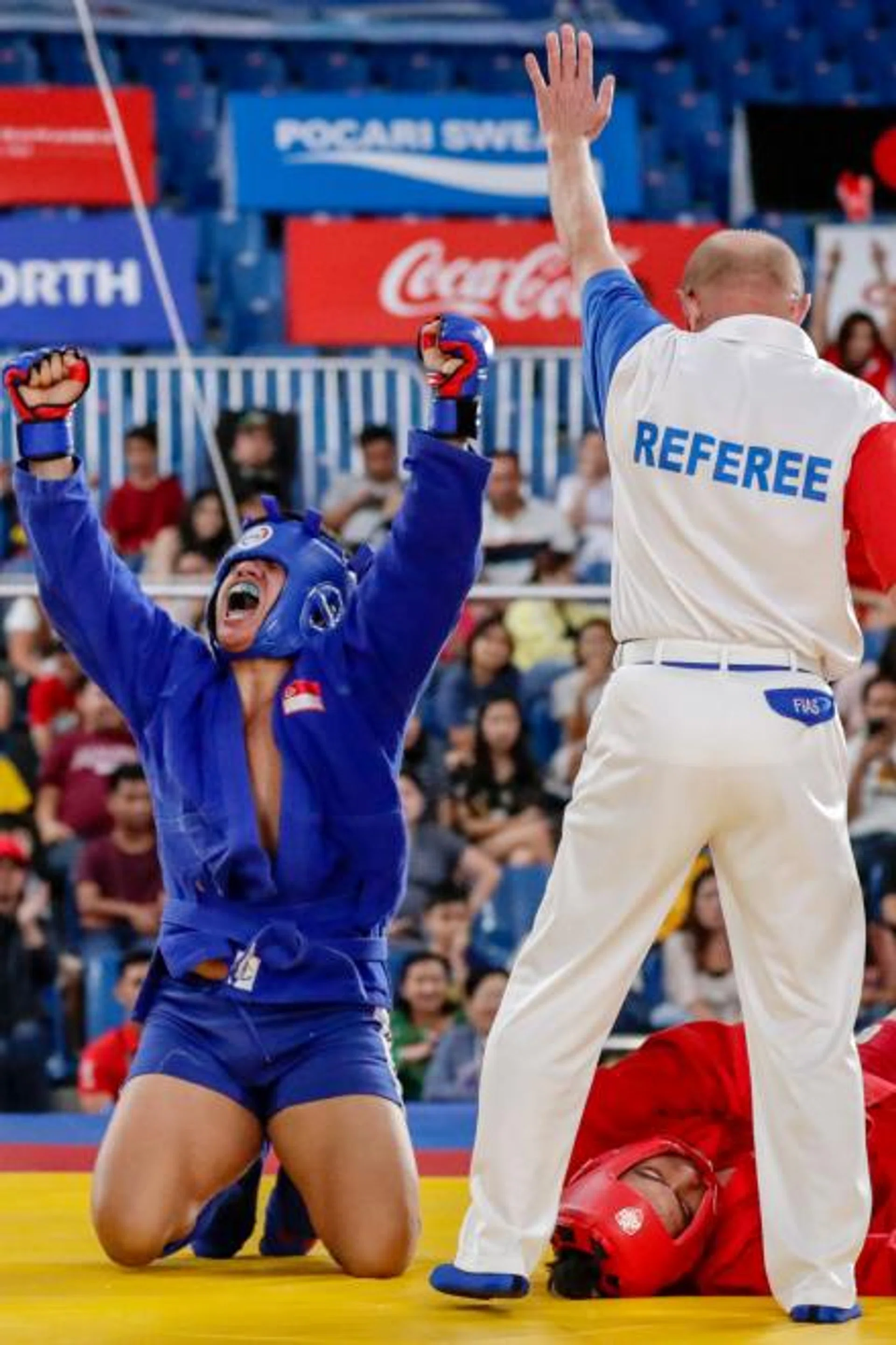 Singapore's Nazri Sutari (in blue) celebrates after defeating Indonesia's Jason Sim. 