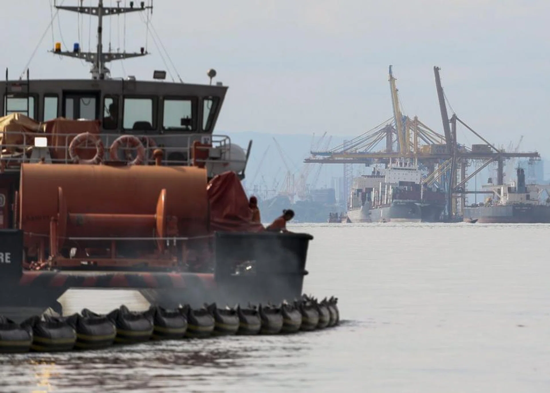 An oil response recovery vessel pictured with the WAN HAI 301 and the APL DENVER (right) berthed at the Pasir Gudang port in Malaysia, as seen from off the coast of Singapore