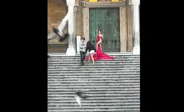 Tourist strips for photo at historic church in Italy