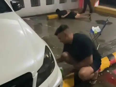 All in a day's work: Man casually washes car while police arrest suspects behind him