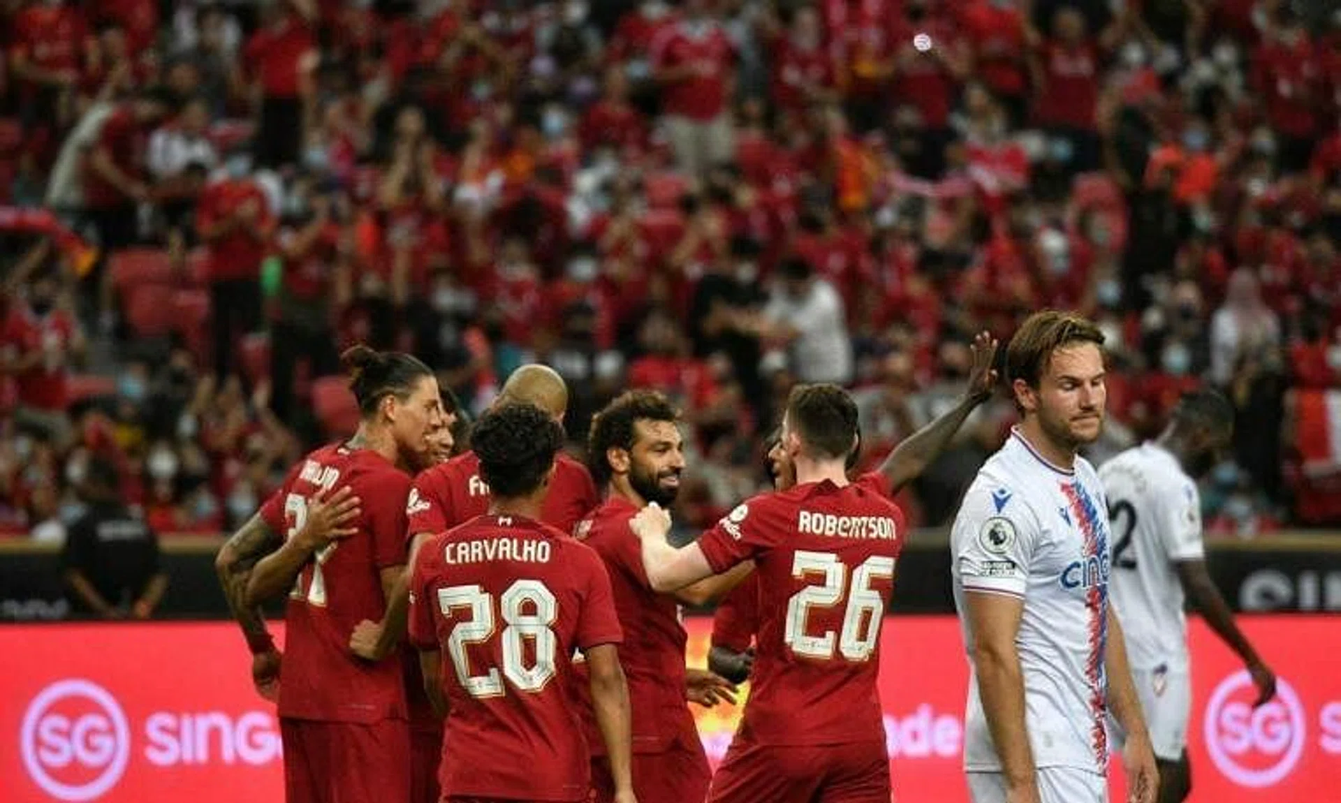 Liverpool teammates congratulating Mohamed Salah after he scored a goal against Crystal Palace at the Standard Chartered Singapore Trophy 2022.