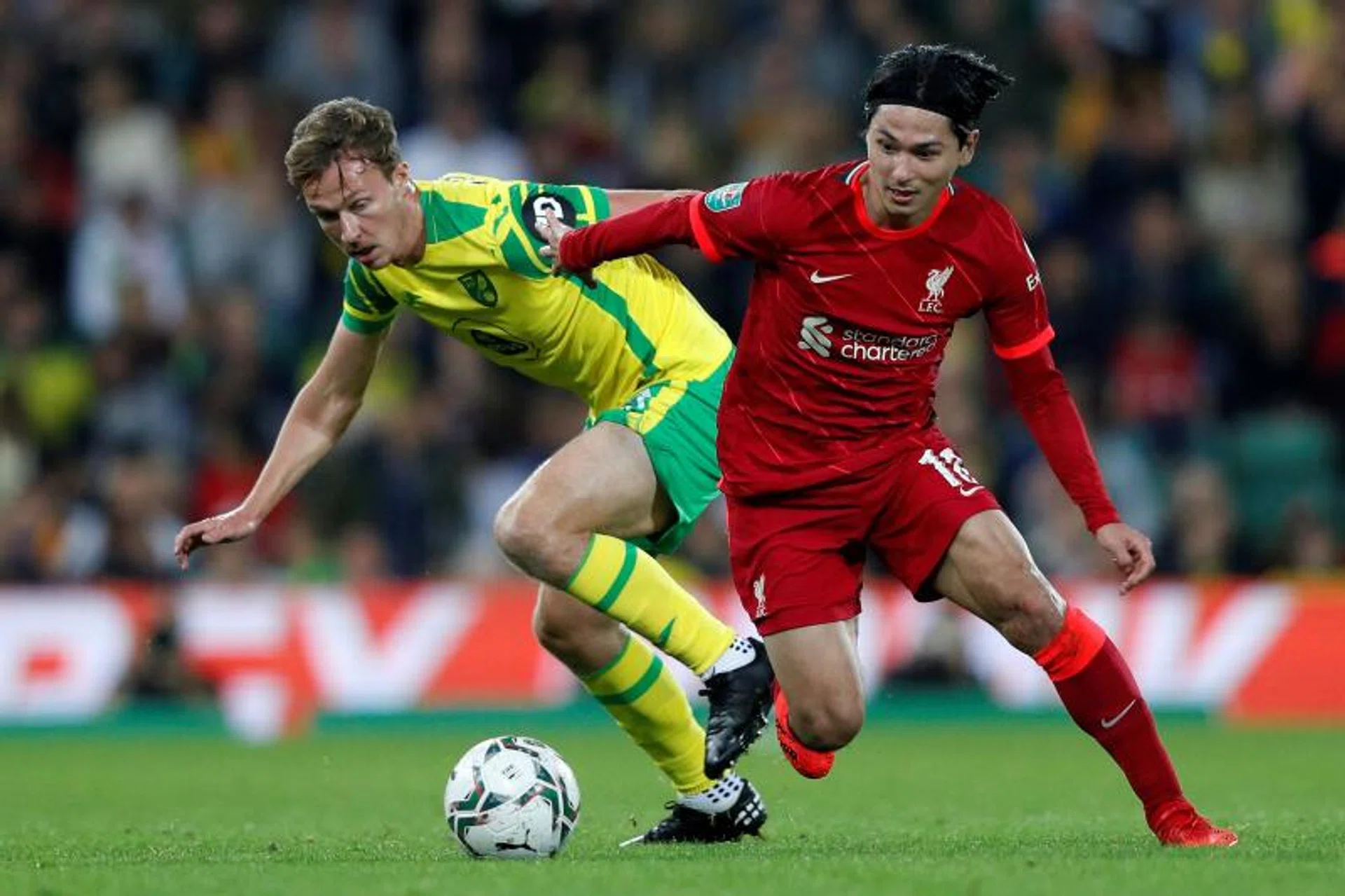 Liverpool’s Takumi Minamino (right) tussles with Norwich City’s Kieran Dowell.