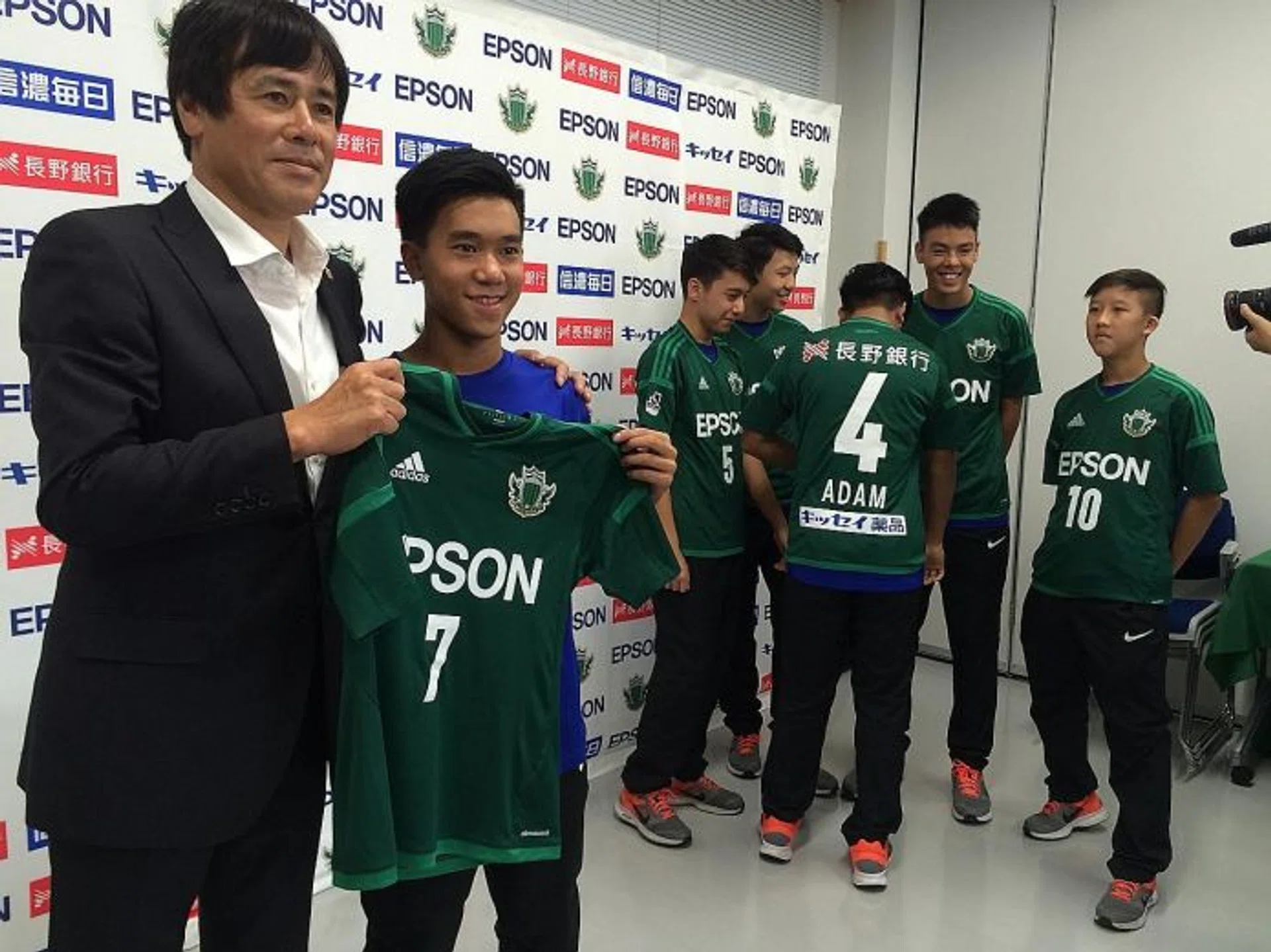 STAR TREATMENT: Matsumoto Yamaga youth academy director Takeshi Yamazaki (far left) presenting personalised jerseys to the six National Football Academy players.