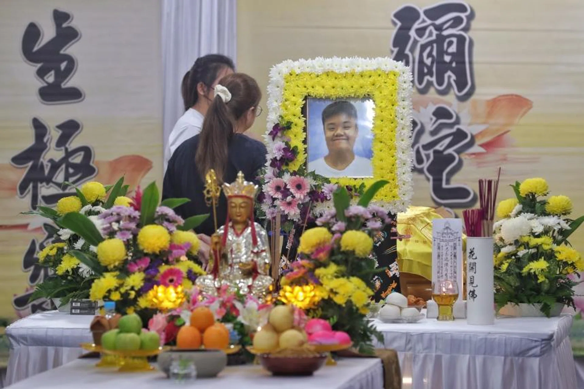 Friends paying their respects at the wake of 24-year-old food delivery rider Jason Tan on April 11, 2022. 
