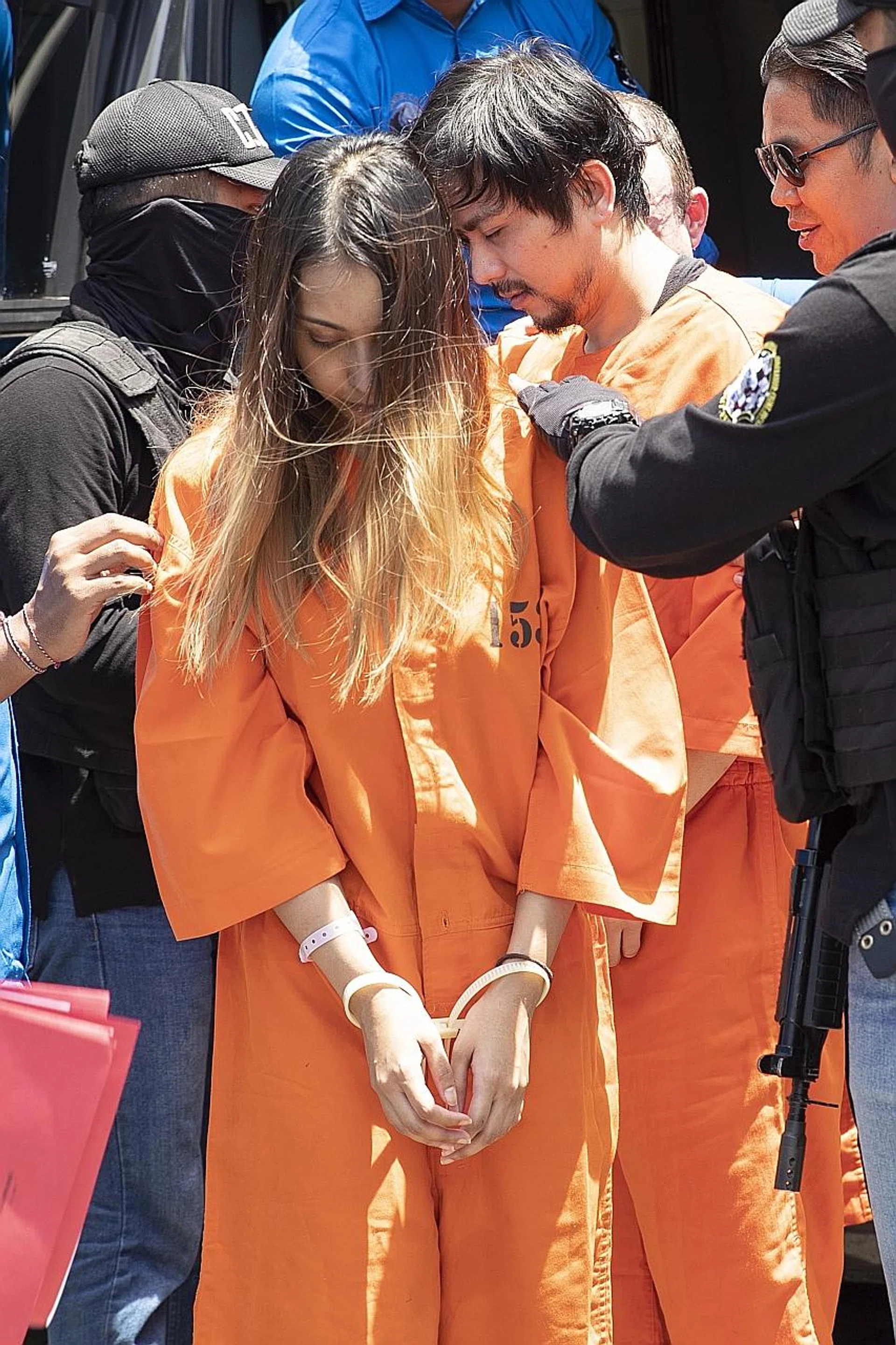 The Singaporean woman being escorted by officials yesterday. 