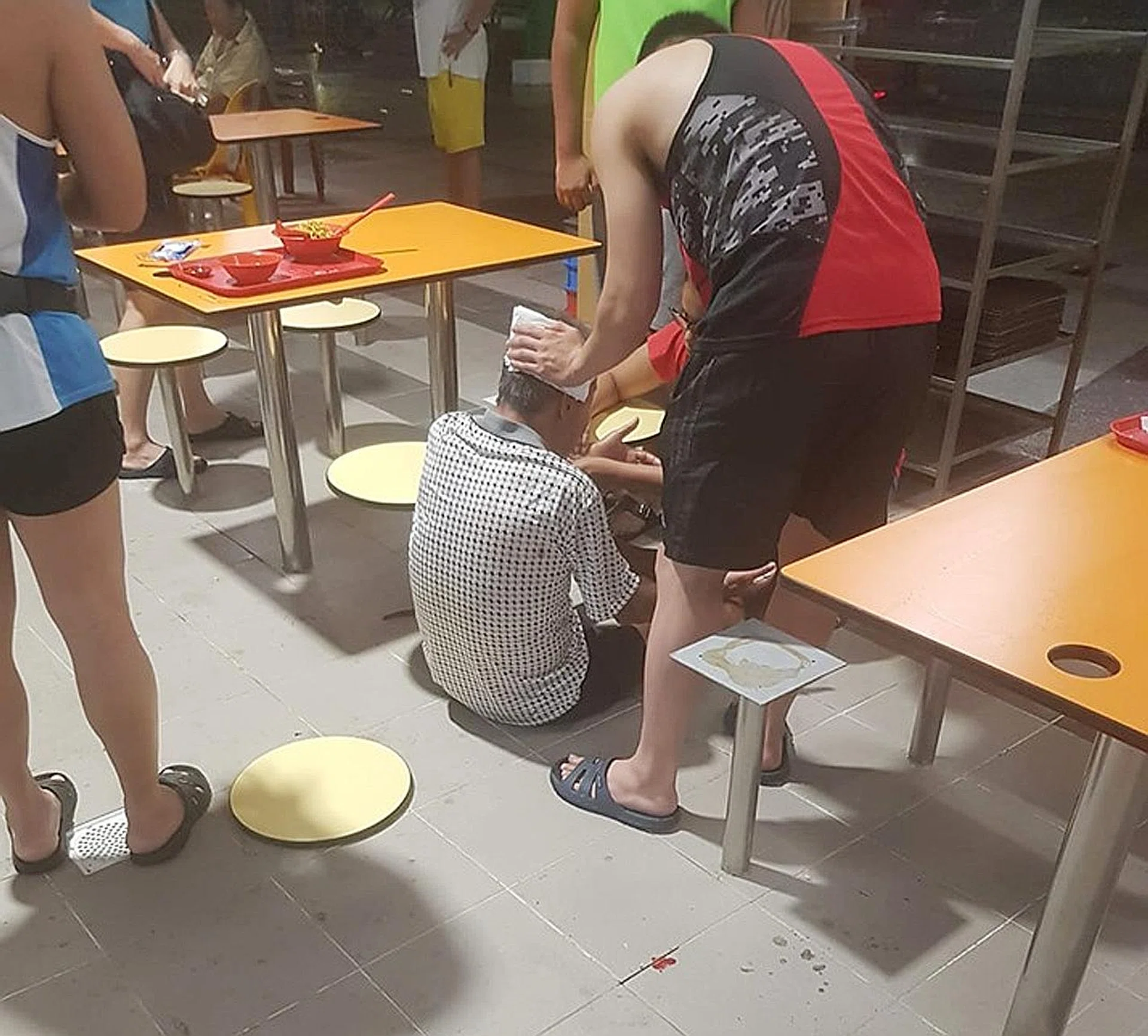 A younger man was seen pressing a paper napkin to the back of the older man's head, presumably to stop the bleeding. 