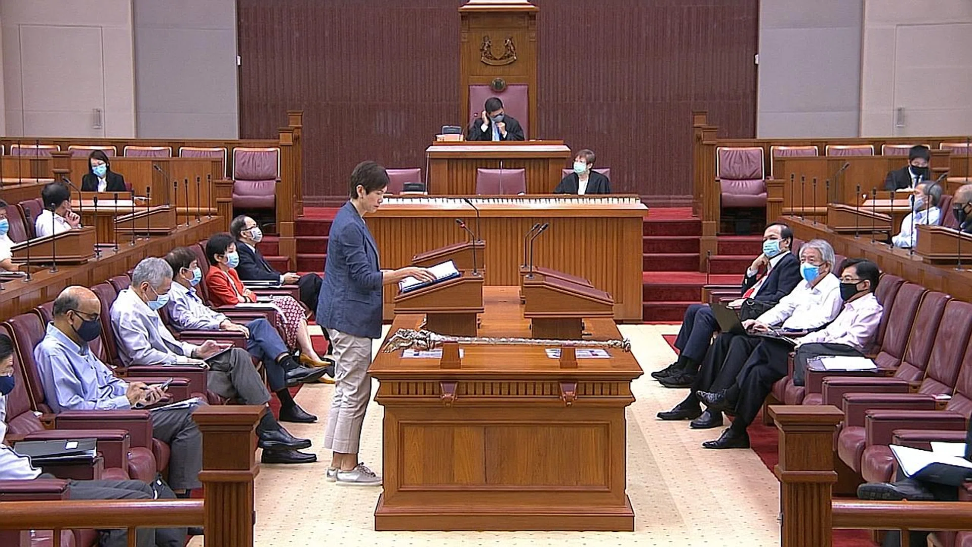 Manpower Minister Josephine Teo speaking yesterday in Parliament, where all MPs donned face masks for the first time. They removed them only when speaking so that they could be heard clearly. 