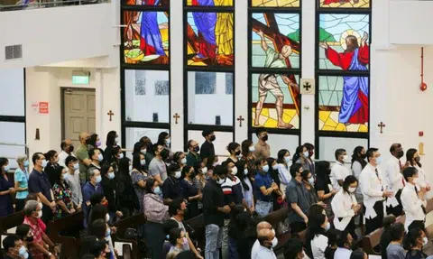Crowds donning masks pack pews and sing hymns in churches on Good Friday