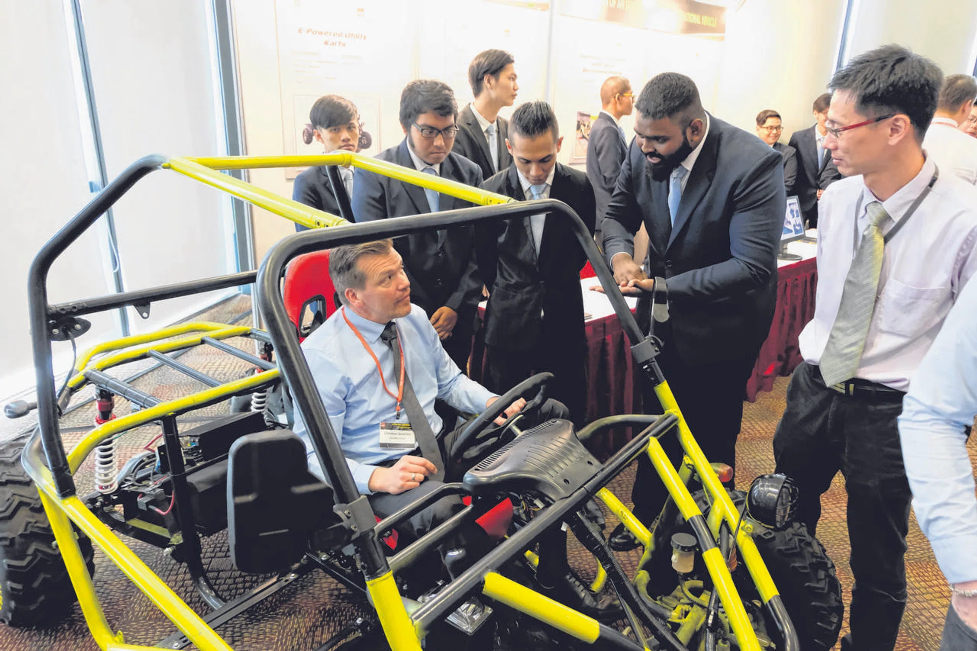 The team showcasing their electric-powered kart to a guest at ITE's inaugural automotive conference. 