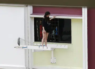 Woman perched on sixth storey laundry rack for 3 hours