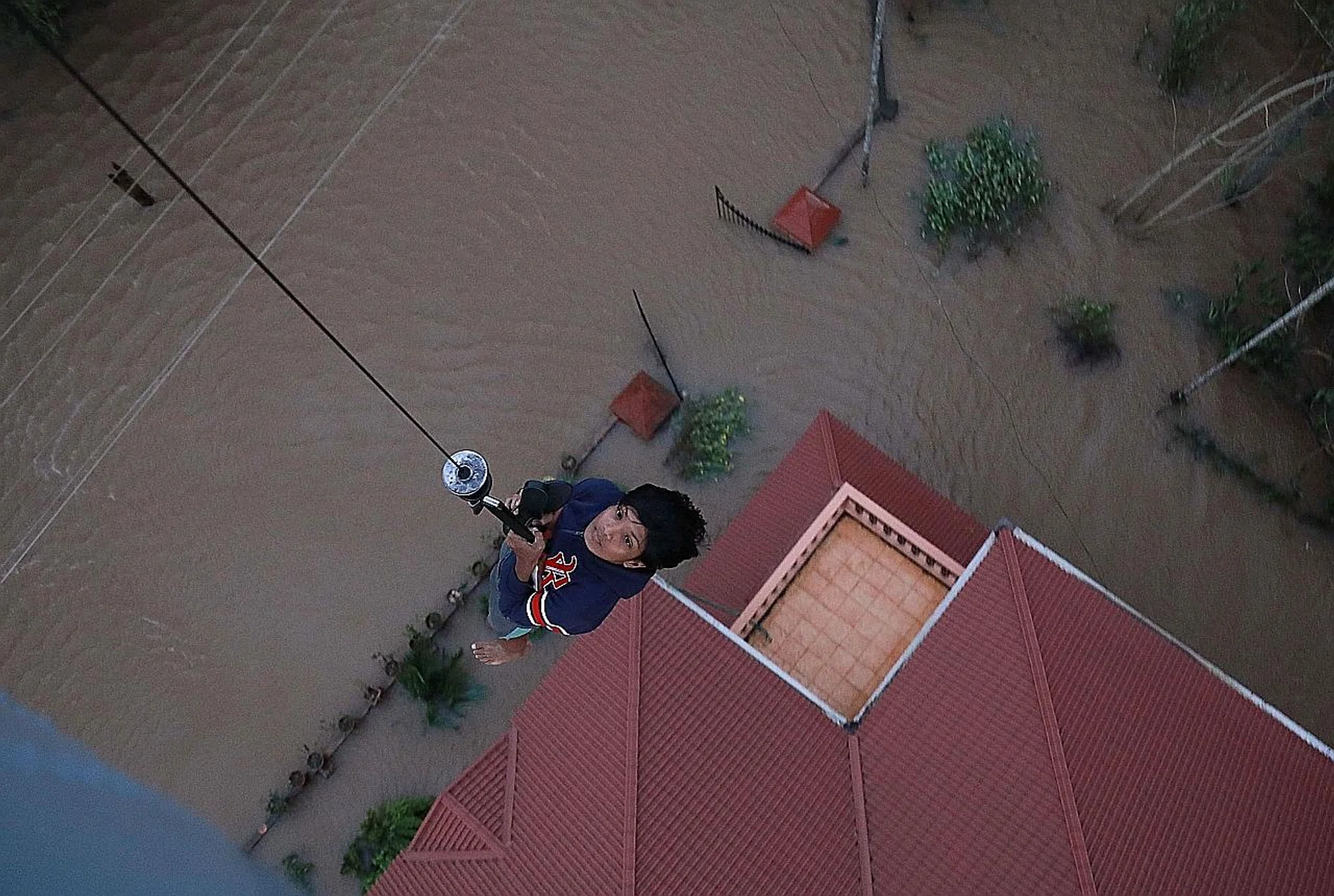 A flood victim is winched up to a rescue helicopter in Paravoor near Kochi, in the Indian state of Kerala, on Saturday. 