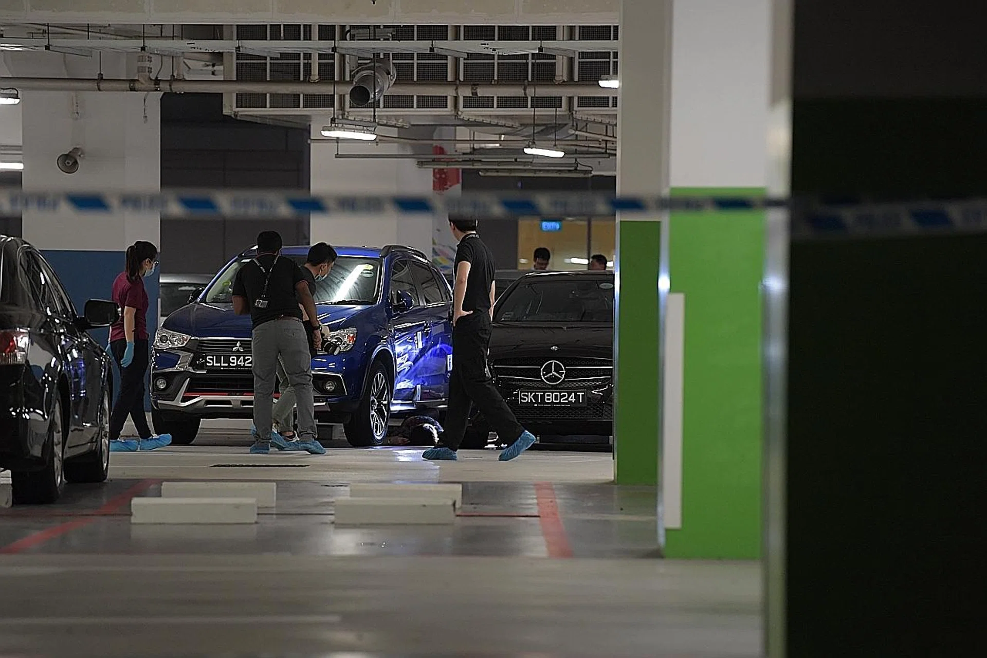 The woman's body was lying between a black Mercedes sedan and a blue Mitsubishi SUV in the carpark. 